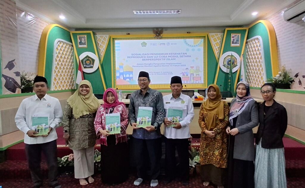 Foto bersama perwakilan Yayasan Gemilang Sehat Indonesia (YGSI) dan jajaran Kementerian Agama di atas panggung aula MTsN 3 Tambakberas, Jombang. Beberapa di antara mereka tampak berdiri berjejer sambil memegang dan menunjukkan Buku Modul SETARA Berperspektif Islam ke arah kamera.