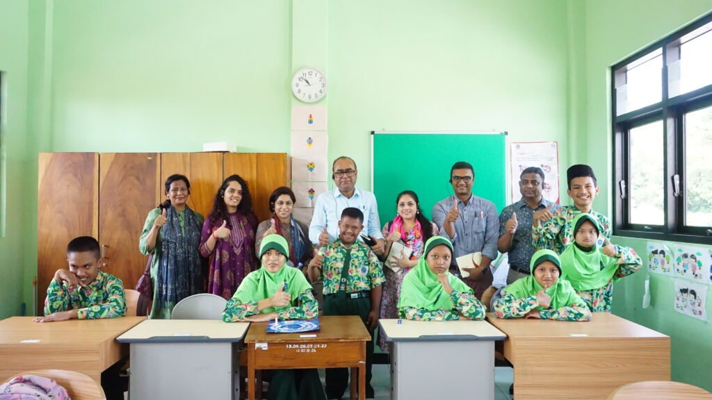 Foto bersama delegasi internasional program Asia Regional Fora bersama para siswa dan guru di dalam ruang kelas sekolah saat kegiatan kunjungan lapangan di Jombang. Mereka tampak tersenyum ceria ke arah kamera sambil memberikan pose acungan jempol bersama.