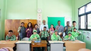 Foto bersama delegasi internasional program Asia Regional Fora bersama para siswa dan guru di dalam ruang kelas sekolah saat kegiatan kunjungan lapangan di Jombang. Mereka tampak tersenyum ceria ke arah kamera sambil memberikan pose acungan jempol bersama.